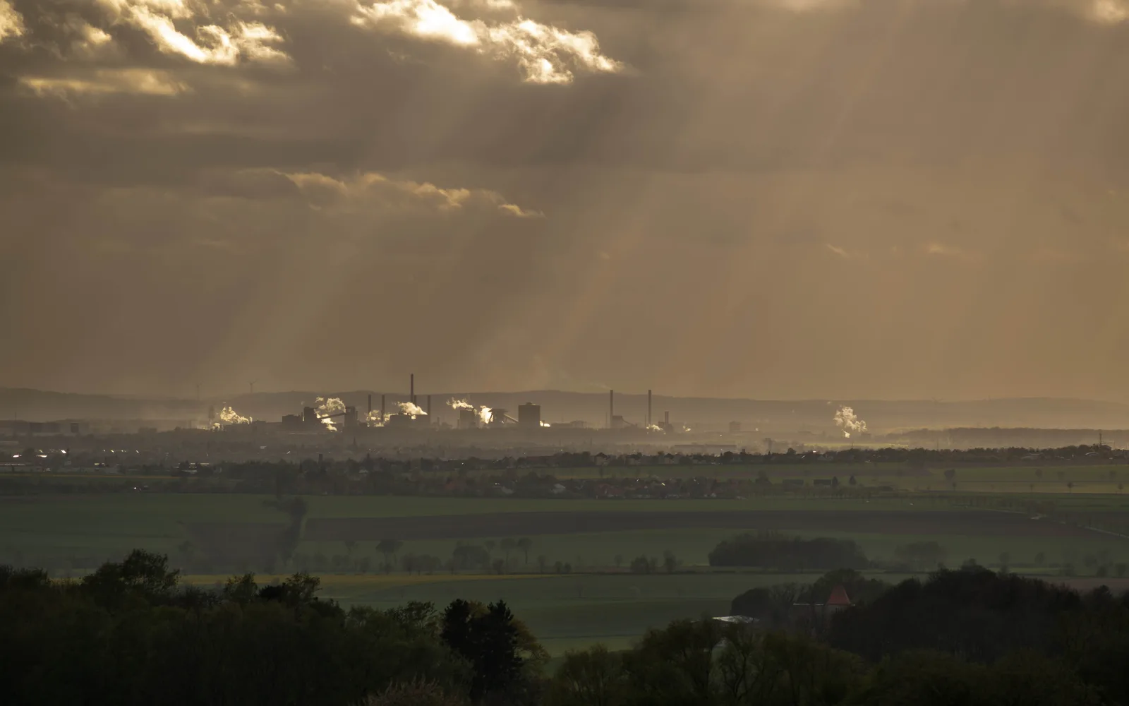 Industrial steel mill facility with towering smokestacks and manufacturing infrastructure